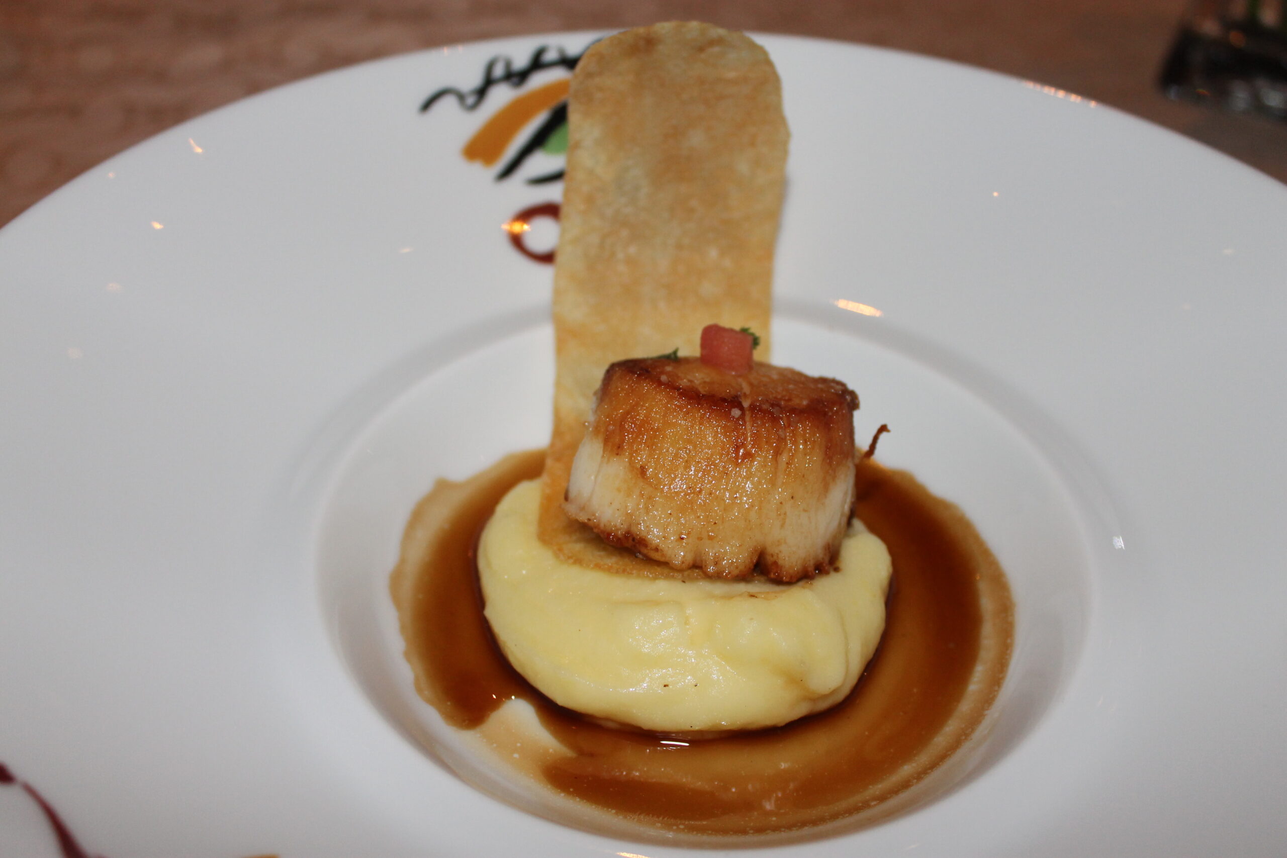 Pan-seared scallop over potatoes at Picasso, one of the best fine-dining restaurants in Las Vegas