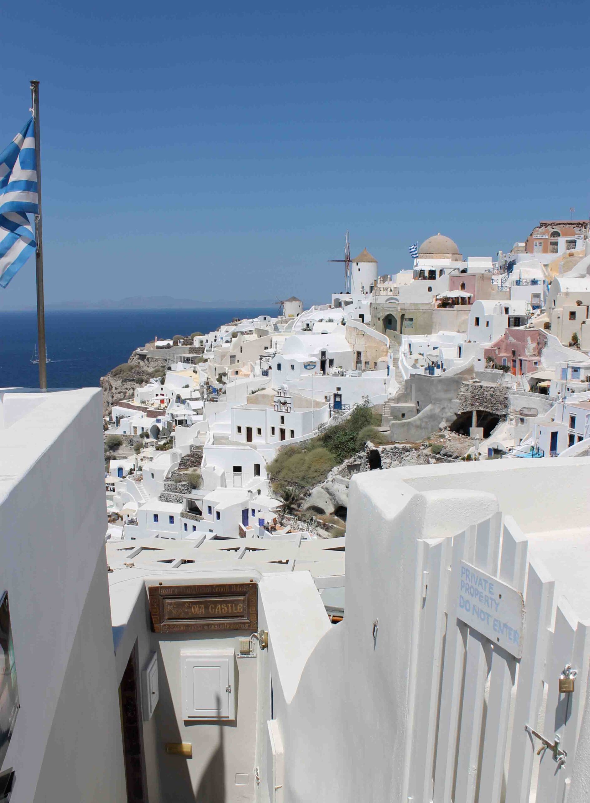 View of Oia Santorini with Greek flag in foreground