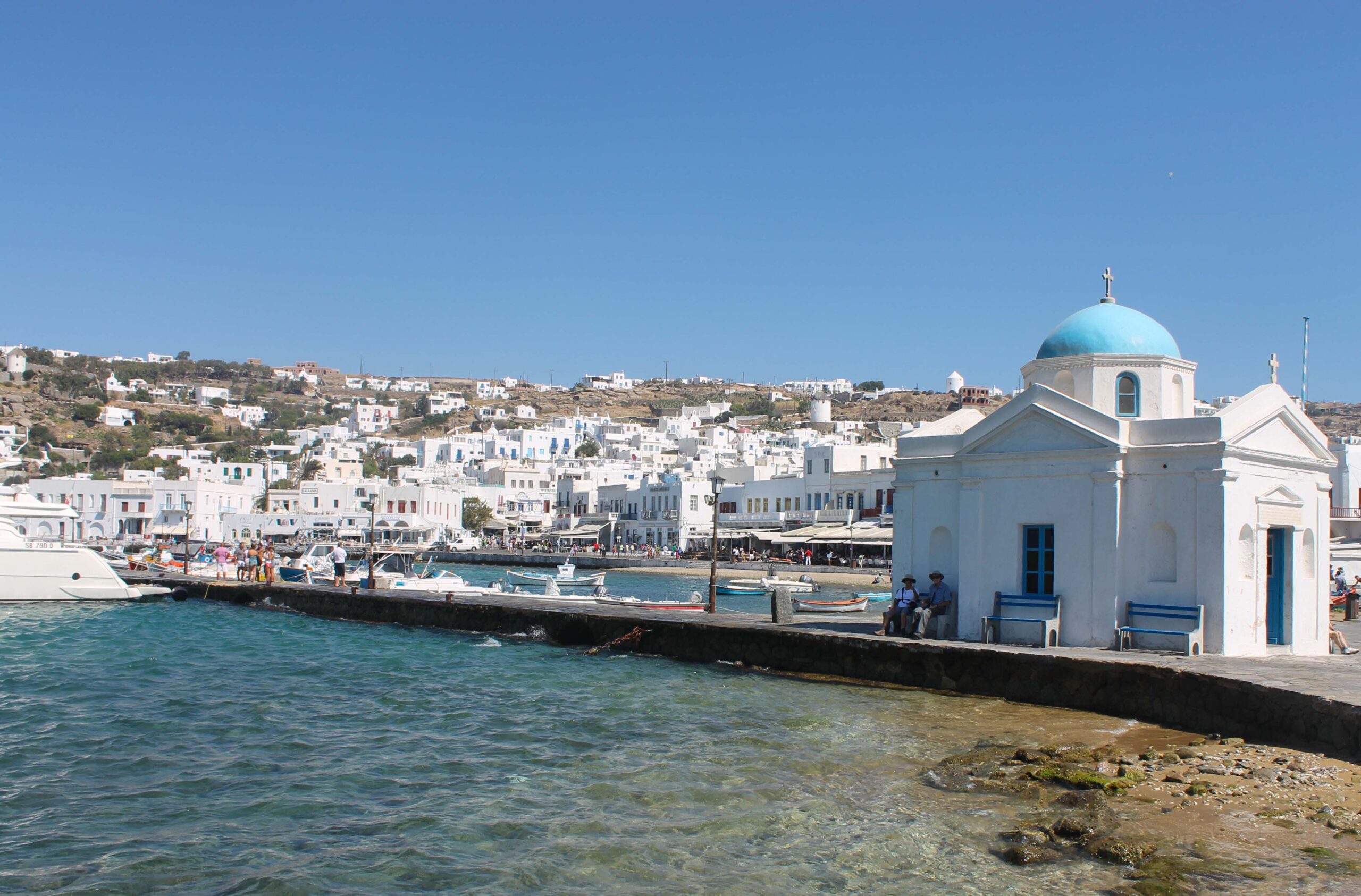 Mykonos Town viewed from the water with a blue-domed church in the foreground