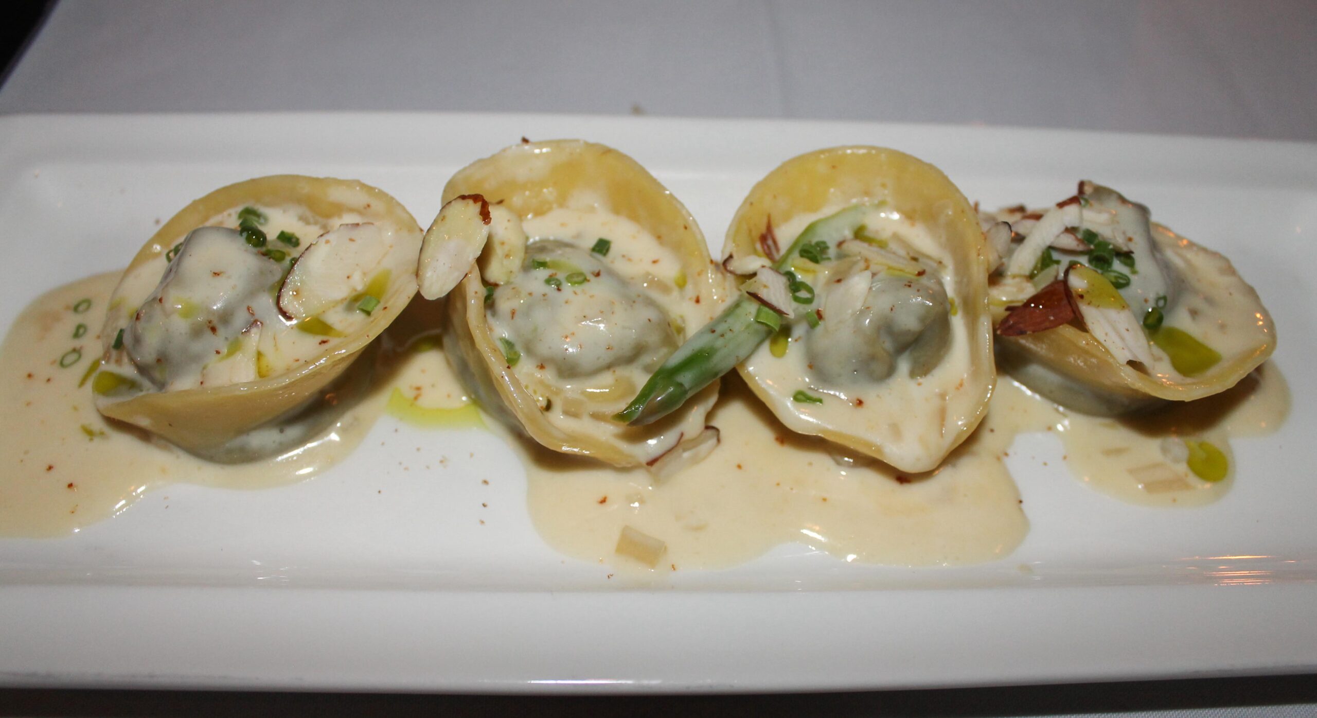 Mushroom ravioli with asparagus, almonds and white wine cream sauce at Mucca Osteria in Portland - a dish I still think about!
