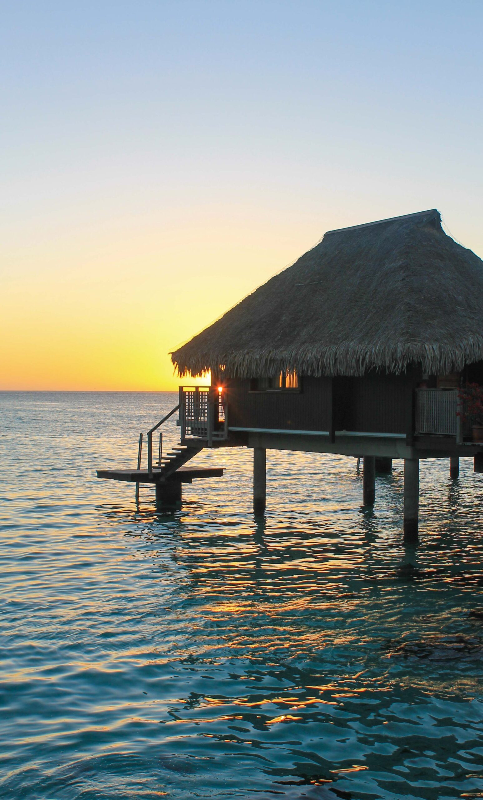 An overwater bungalow in Moorea at sunset